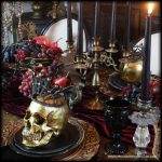 How to create a haunting yet luxurious Halloween Dinner Party fit for a Skull King or Queen… Burgundy Silk Velvet Table Runner, Antique Gold Candelabras, chunky gold candlesticks, Black Candles, Bowls of Dark Fruits, Black Velvet Linens, Gothic Black Glass Goblets, and Black and Gold Skulls wearing crowns | Me and Annabel Lee Blog